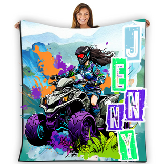 a woman holding up a blanket with a picture of a person riding a four wheeler