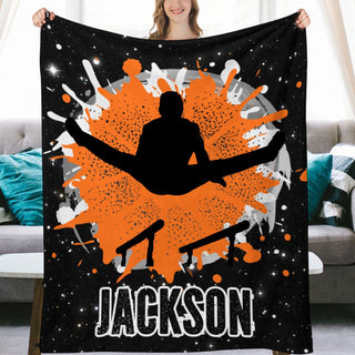 a woman holding up a black and orange blanket