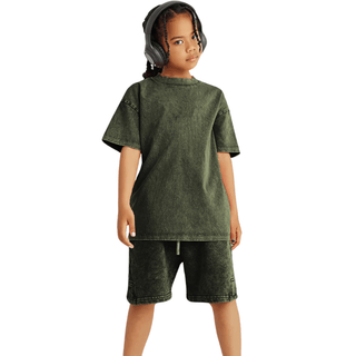 a young boy wearing a green shirt and shorts