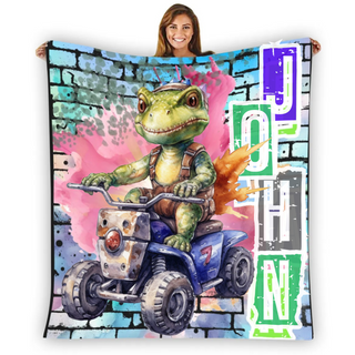 a woman holding up a blanket with a picture of a frog riding a four wheeler