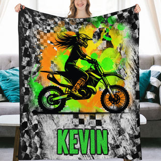 a woman holding up a blanket with a picture of a person on a dirt bike