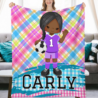 a girl holding a soccer ball and a personalized blanket