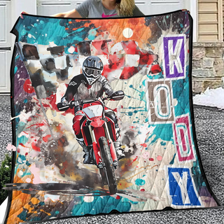 a woman holding up a quilt with a picture of a motorcyclist on