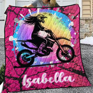 a woman holding a pink blanket with a picture of a girl on a dirt bike