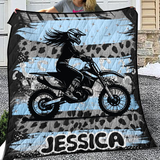 a woman holding up a blanket with a picture of a girl on a dirt bike