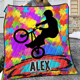 a woman is holding a colorful blanket with a picture of a person on a bike