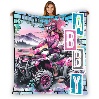 a woman holding up a blanket with a picture of a woman on a four wheeler