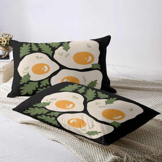 two pillows with eggs on them sitting on a bed