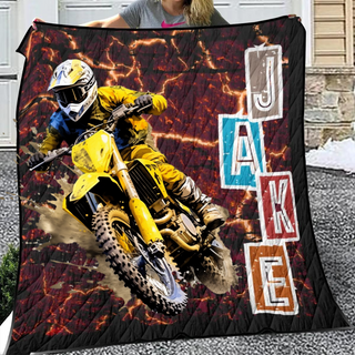 a woman holding a blanket with a picture of a dirt bike rider