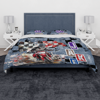 a bed with a motorcycle themed comforter and pillows