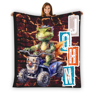 a woman holding up a blanket with a picture of a turtle riding a four wheeler