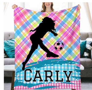 a woman holding a colorful blanket with a soccer ball on it