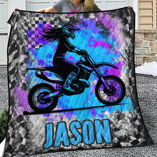 a woman holding up a blanket with a picture of a person on a dirt bike