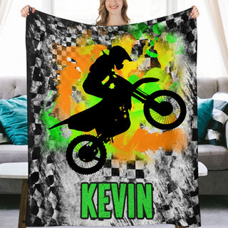 a woman holding up a blanket with a picture of a person on a dirt bike