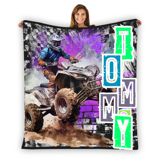 a woman holding up a blanket with a picture of a person riding a quad quad