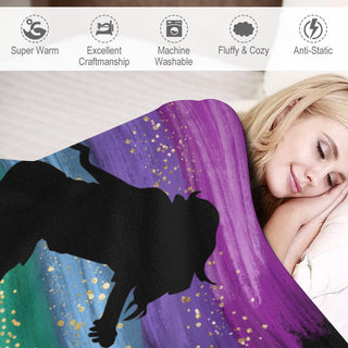 a woman laying in bed under a colorful blanket