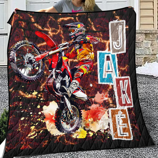 a woman holding up a blanket with a picture of a dirt bike rider