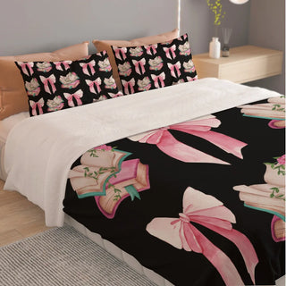 a bed with a black and pink comforter and pillows