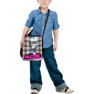 a young boy holding a pink and black bag