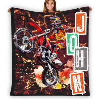 a woman holding up a blanket with a picture of a dirt bike