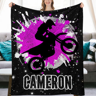 a woman holding a black and purple blanket with a picture of a person on a