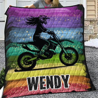 a woman sitting on a motorcycle on a rainbow blanket