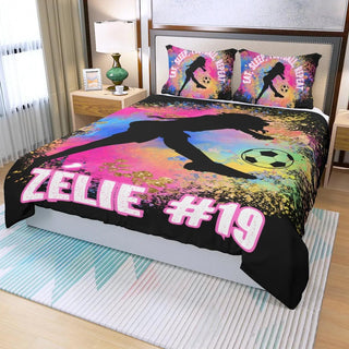 a bed with a soccer themed comforter and pillows