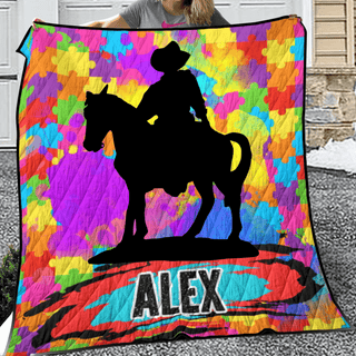 a woman holding a quilt with a picture of a cowboy on a horse