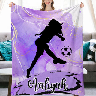 a woman holding a purple blanket with a soccer player on it