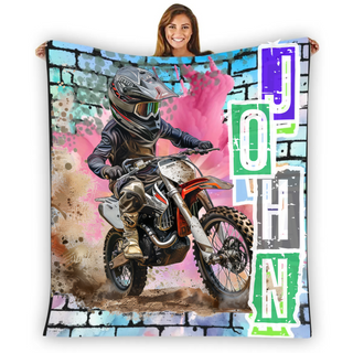 a woman holding a blanket with a picture of a dirt bike rider