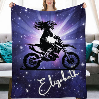 a woman holding up a blanket with a picture of a person on a dirt bike