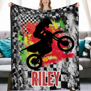 a woman holding up a blanket with a picture of a person on a dirt bike