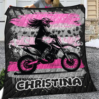 a woman holding up a pink and black blanket