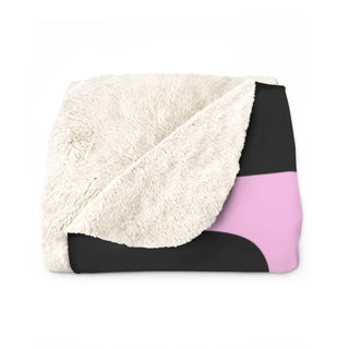 a pink and black blanket on a white background