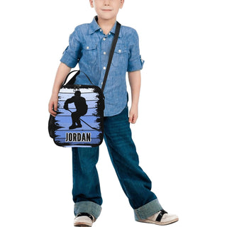 a young boy holding a bag with a picture of a man on it