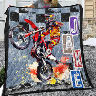 a woman holding a blanket with a picture of a person on a dirt bike