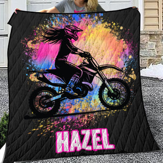 a woman holding up a blanket with a picture of a girl on a dirt bike