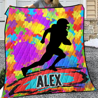 a woman is holding a quilt with a picture of a football player