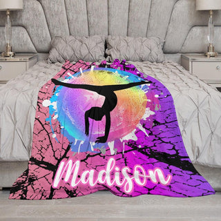 a bed with a pink, purple and blue comforter with a girl doing a