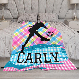 a bed with a comforter with a picture of a girl kicking a soccer ball