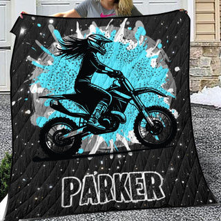 a woman holding up a blanket with a picture of a person on a dirt bike