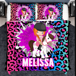 a girl riding a horse on a pink and blue leopard print bed set