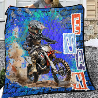 a woman holding up a blanket with a picture of a dirt bike