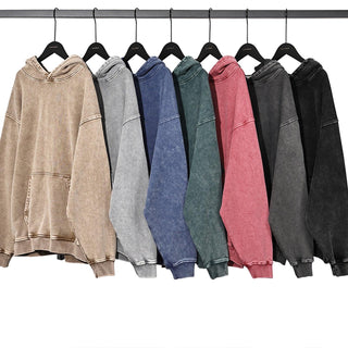 a row of different colored sweatshirts hanging on a rack