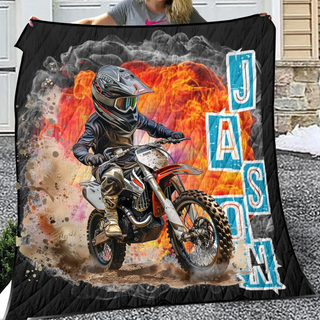 a woman holding a blanket with a picture of a dirt bike rider