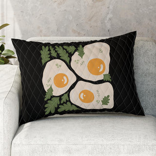 a black pillow with three fried eggs on it