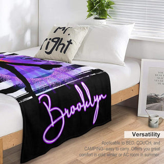 a bed with a black and purple blanket on top of it