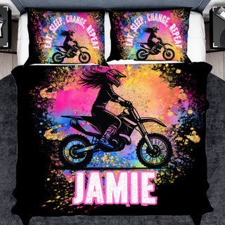 a bed with a black cover with a picture of a girl on a dirt bike