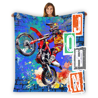 a woman holding a blanket with a picture of a dirt bike rider