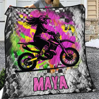 a woman holding up a blanket with a picture of a girl on a dirt bike